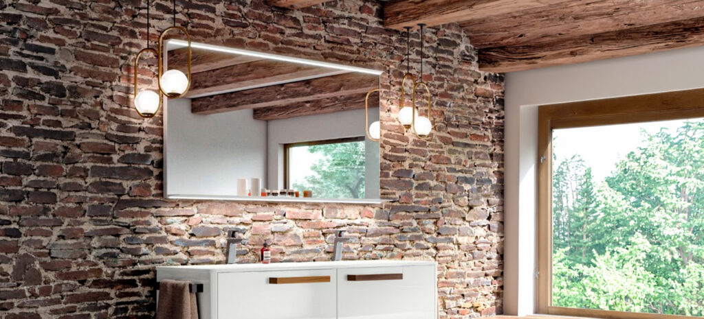 Ein modernes Bad mit Holzdecke und Backsteinwand, beleuchtet von stilvollen Glühbirnen, schafft eine einladende Atmosphäre | © ELEKTRA.