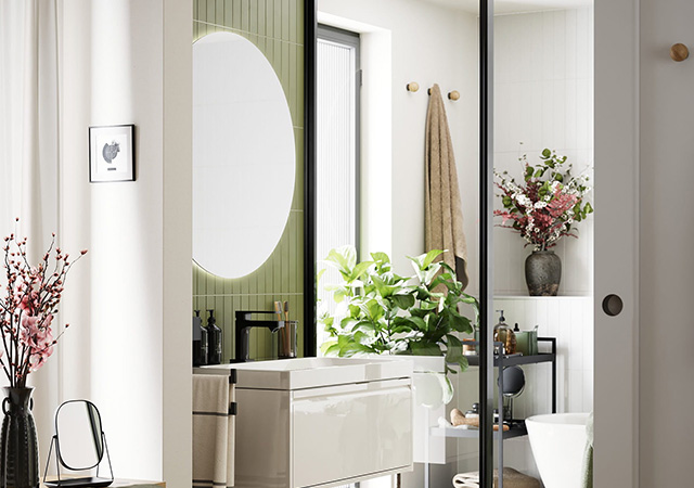 Ein modernes Bad mit eleganten Möbeln, Pflanzen und einem großen runden Spiegel schafft eine harmonische bad-milieu-totale Atmosphäre.