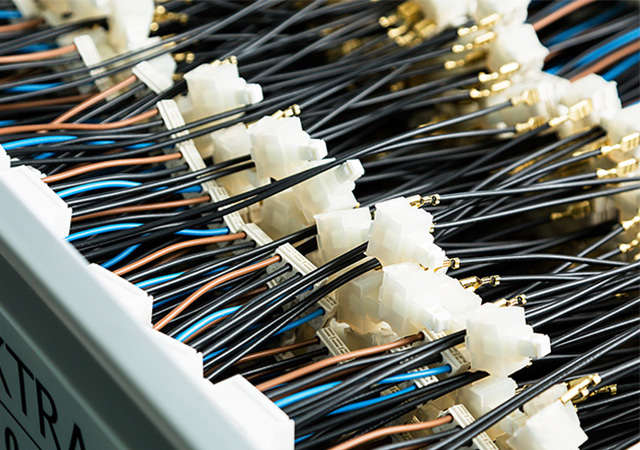 Eine Vielzahl von Kabeln und Steckverbindungen zeigt die präzise Technik hinter industriellen Lichtlösungen und Sensorik.