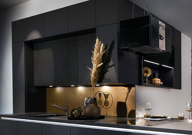 Moderne schwarze Küche mit stilvollen Akzenten und indirekter Beleuchtung, die ein elegantes Ambiente schafft.