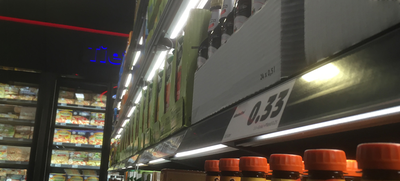 Ein gut beleuchteter Supermarktregal zeigt verschiedene Produkte, während Preislabels klar lesbar sind. | © ELEKTRA