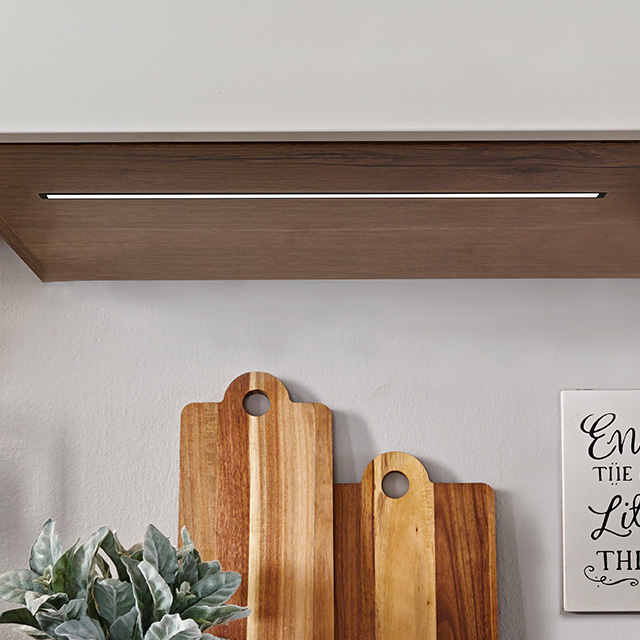 Ein eleganter ld8124-haengeschrank mit sanfter Beleuchtung, über einem Holzbrett und einem dekorativen Schild platziert.