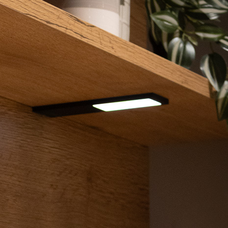 Ein elegantes schwarzes Regal mit integrierter Beleuchtung schafft eine moderne Atmosphäre in jedem Raum.