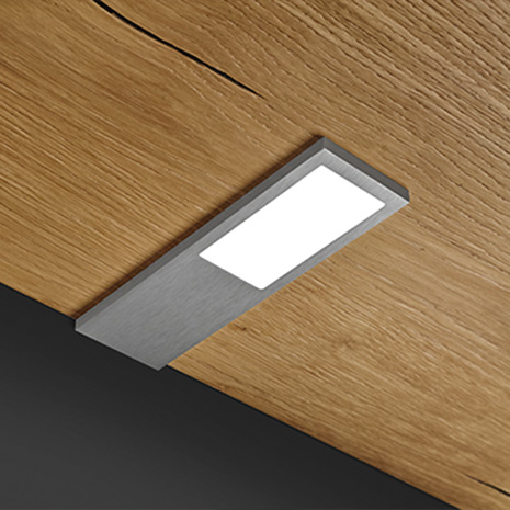 Ein eleganter, silberner Regalboden aus dem Modell ld8142 hebt das moderne Design des Raumes hervor und ergänzt die Beleuchtung.