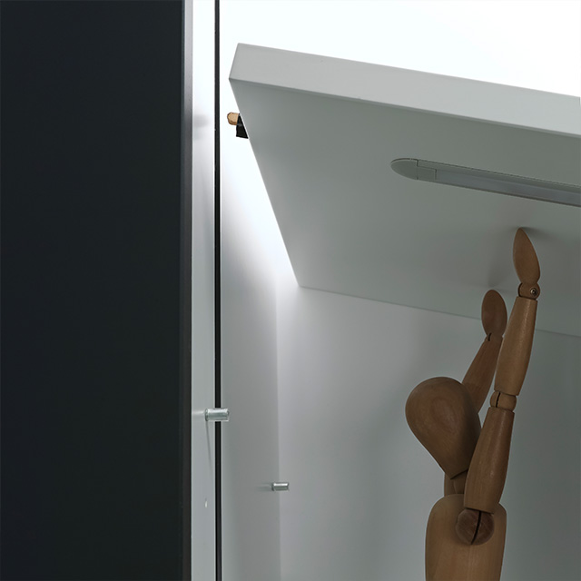 A mannequin reaches for a top shelf on the Vario-D10 shelving unit, which is installed in a modern room.